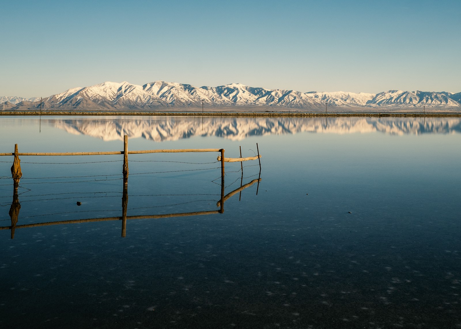snow covered mountain near body of water during daytime
