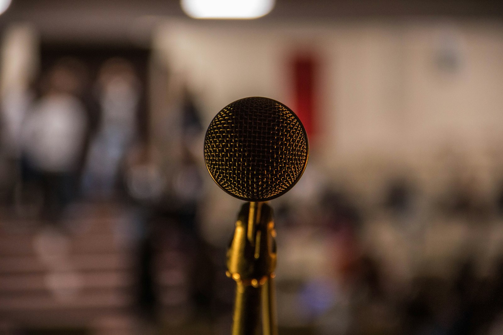 A microphone on a stand at a public forum, ready for questions