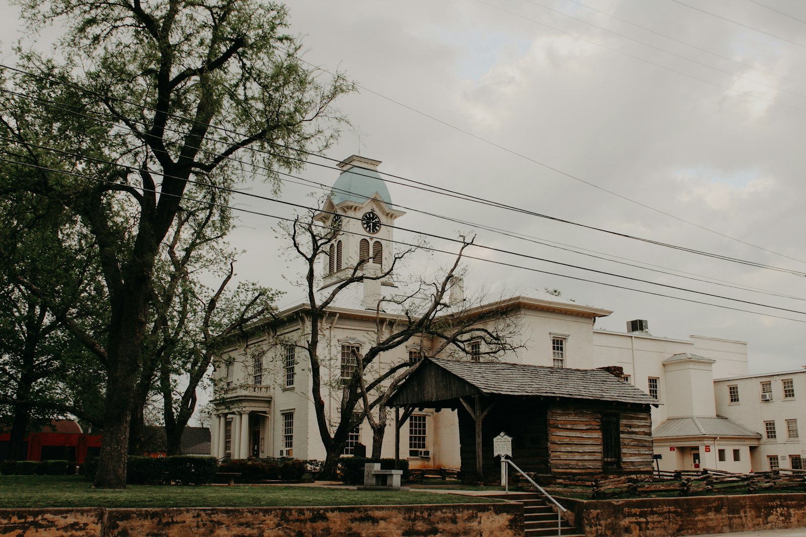 A historic county courthouse with a clock tower framed by trees
