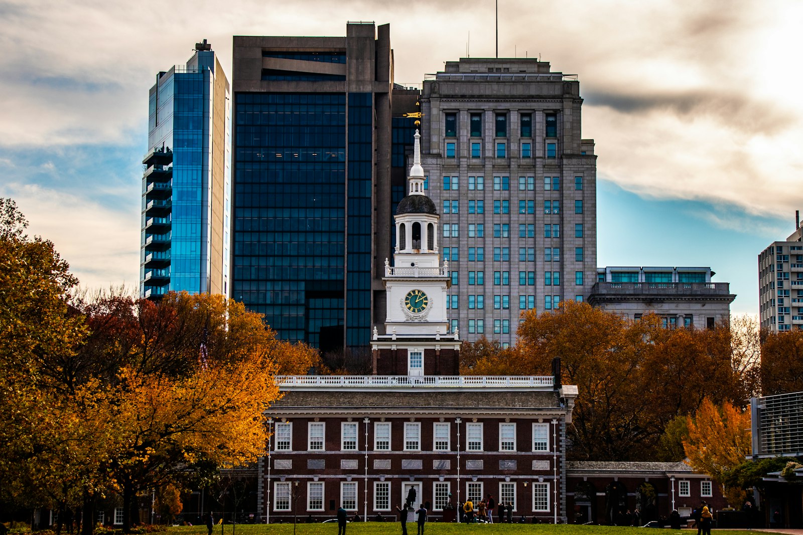 a large municipal building with a clock tower in the middle of a park