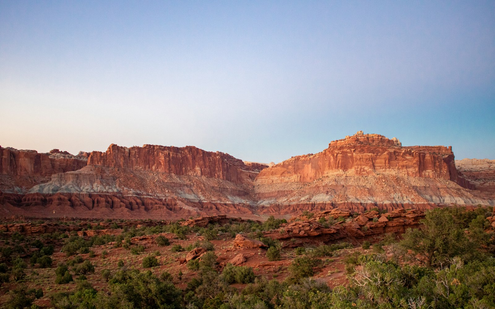 A scenic view of the Utah desert with a mountain in the background